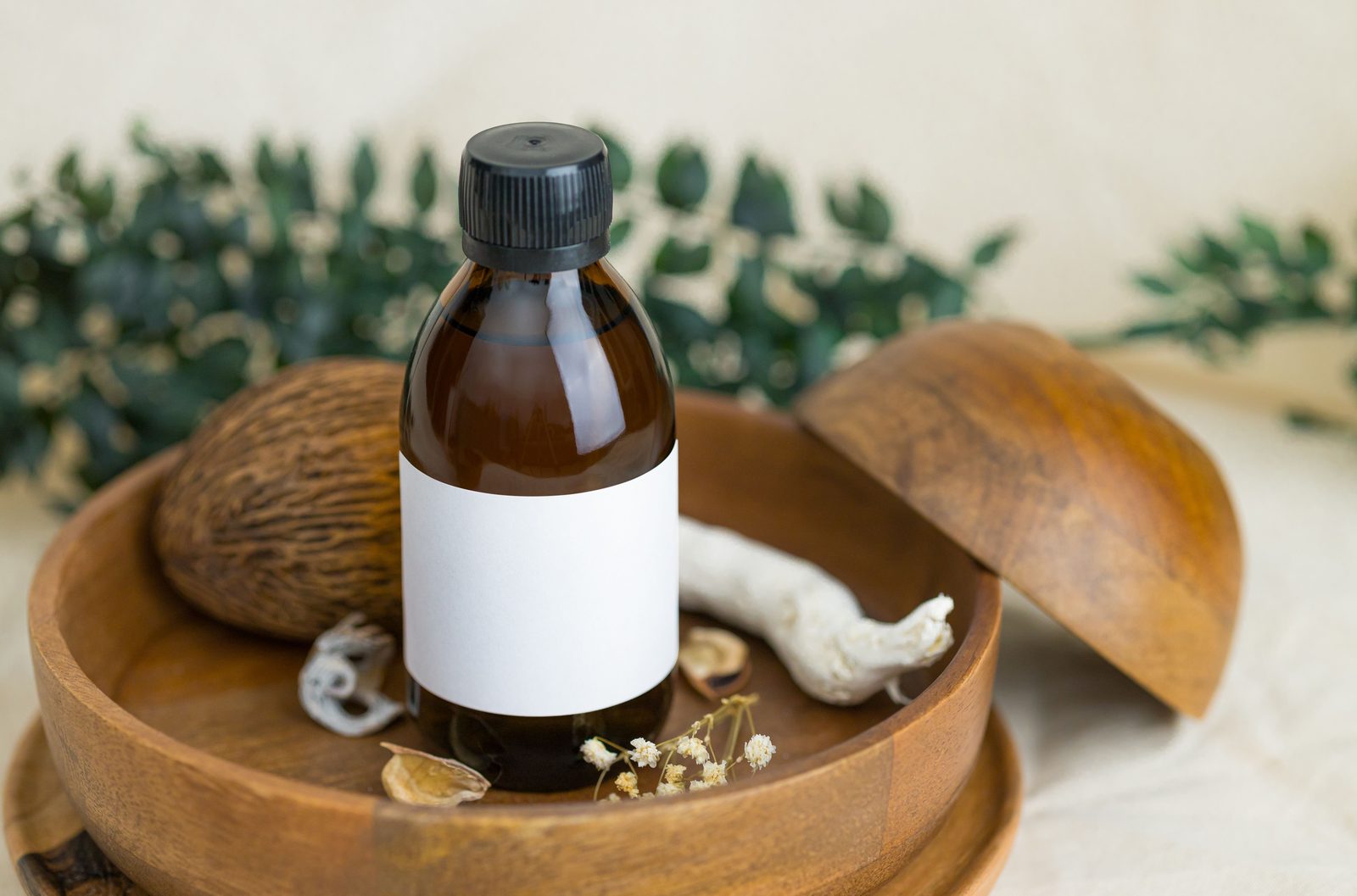 Amber skincare bottle with a blank label in a botanical setting